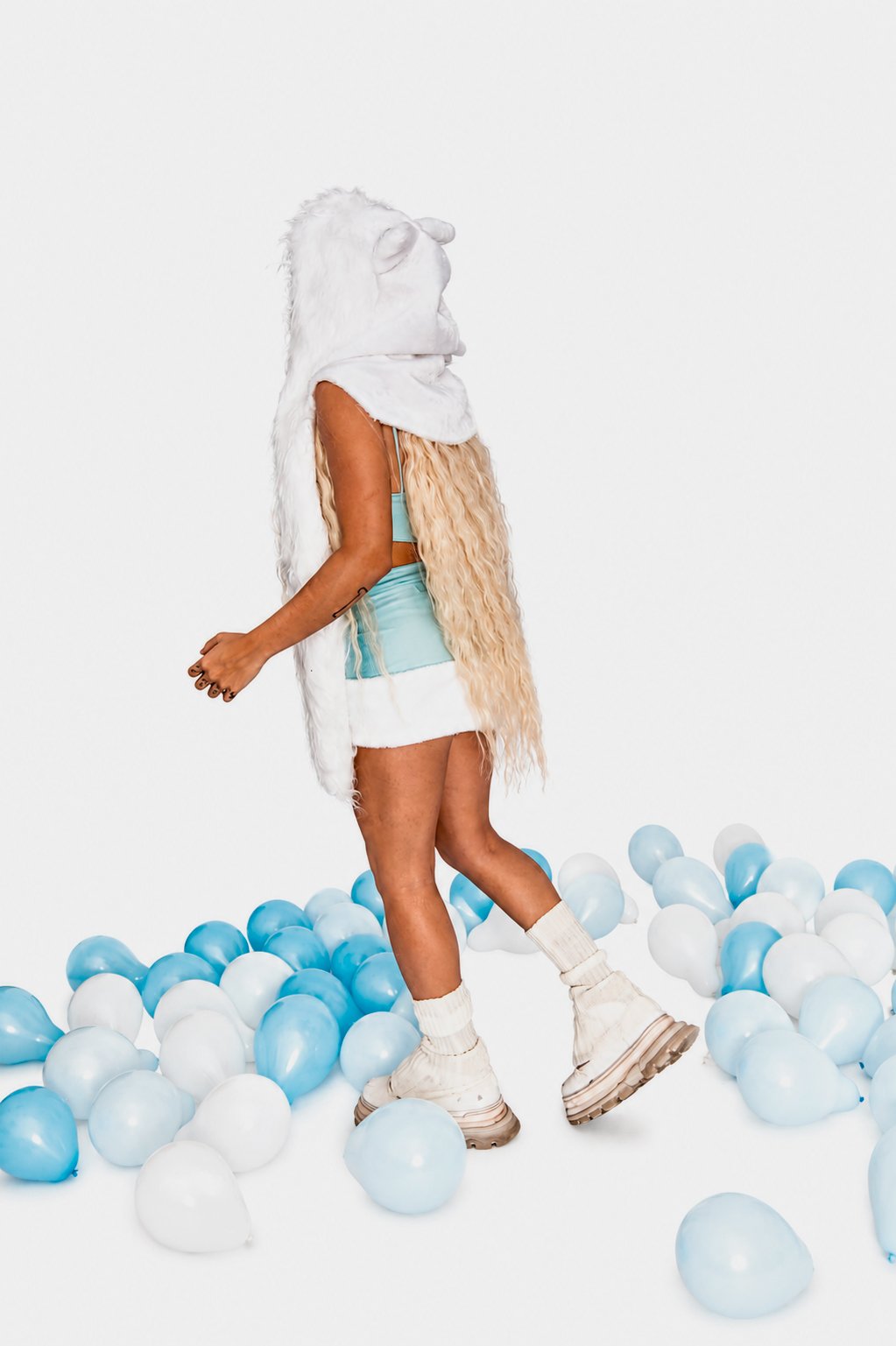 LUNA KI walking through blue balloons for “Por no estar”