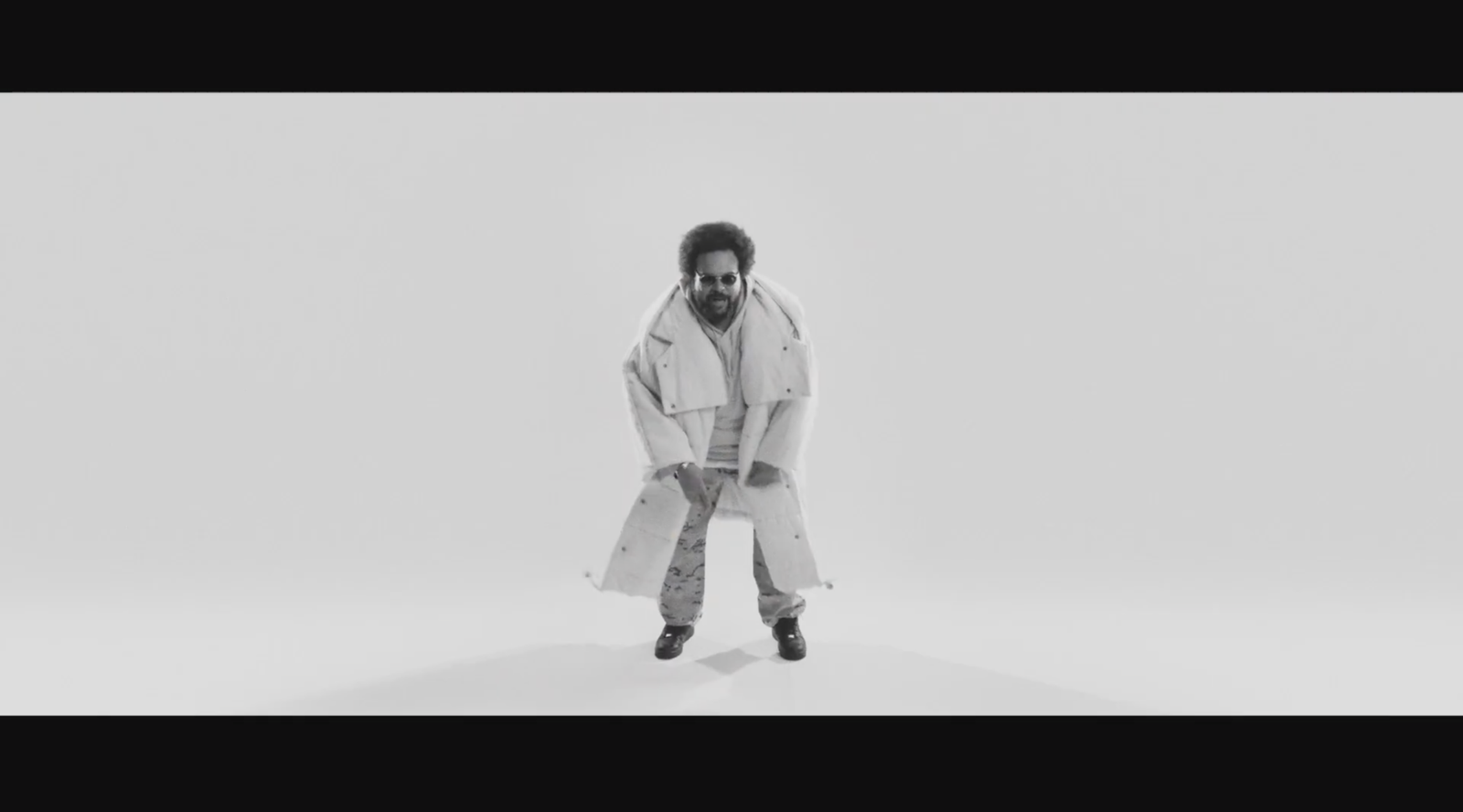Carlos Jean performing in a monochromatic studio setup for the “Downtown” music video.